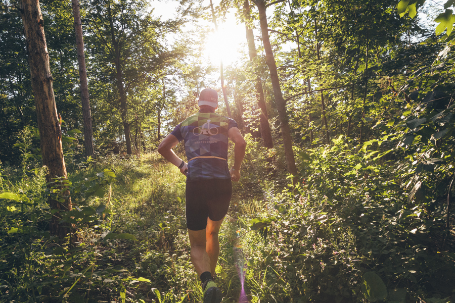 Trailrunner von hinten mit tiefstehender Sonne im Gegenlicht