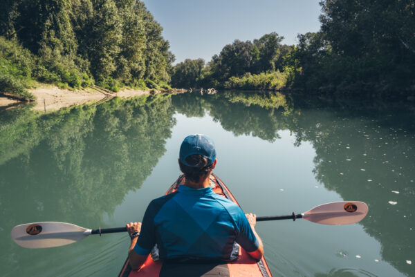 Mann in Kajak in einem ruhigen Fluss in der Natur