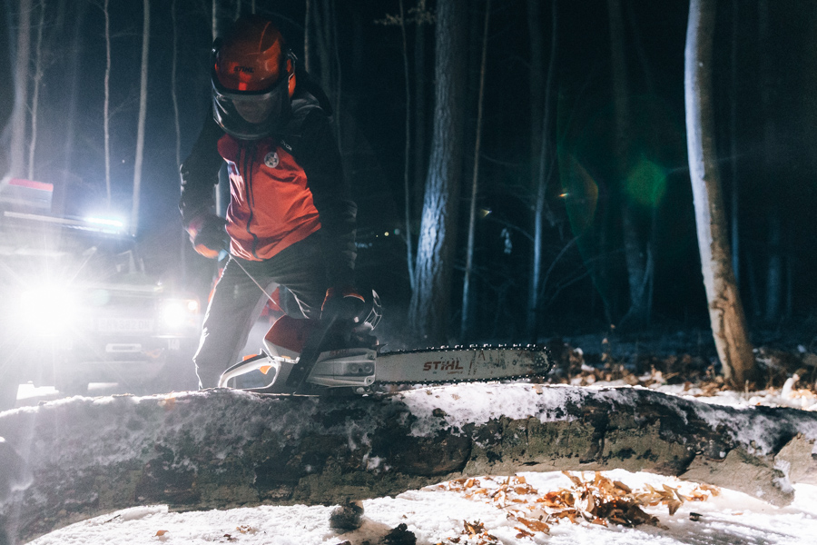 Bergretter mit Motorsäge nachts im Wald im Einsatz